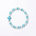 The Aether Cross energy bracelet by SpiritPalette displayed on a clean white background, showcasing cyan and white cat-eye gemstone beads with a turquoise cross.