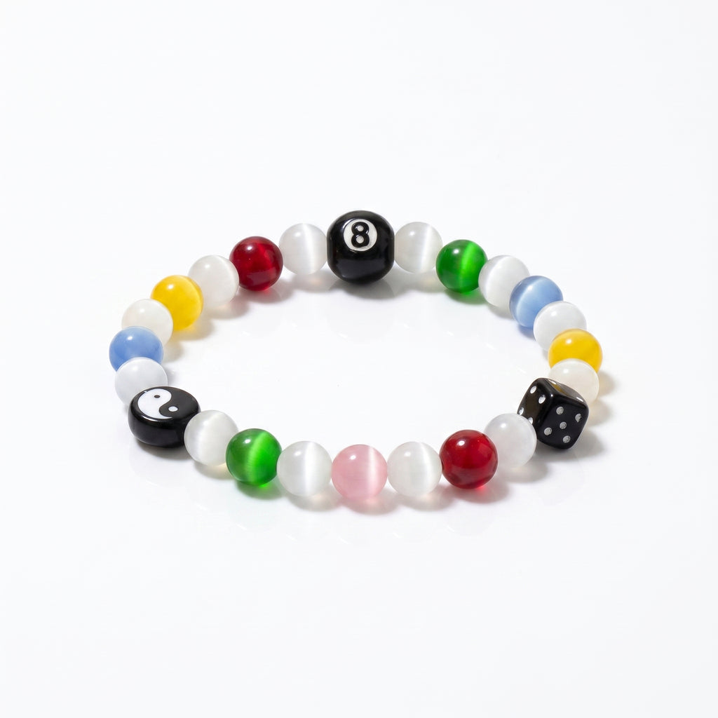 The SpiritPalette Chroma Rebel multi-color cat-eye crystal bracelet displayed on a clean white background, highlighting its signature black 8-ball, yin-yang charm, and lucky dice.