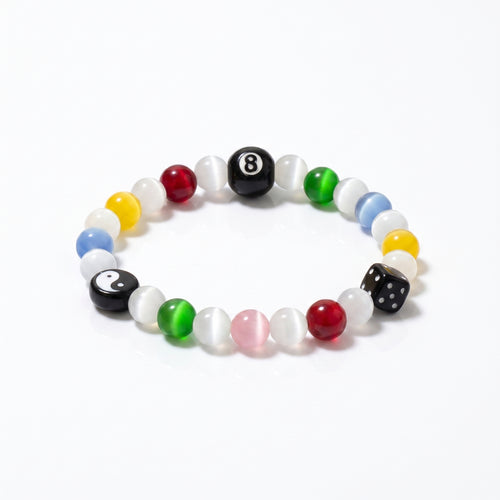The SpiritPalette Chroma Rebel multi-color cat-eye crystal bracelet displayed on a clean white background, highlighting its signature black 8-ball, yin-yang charm, and lucky dice.