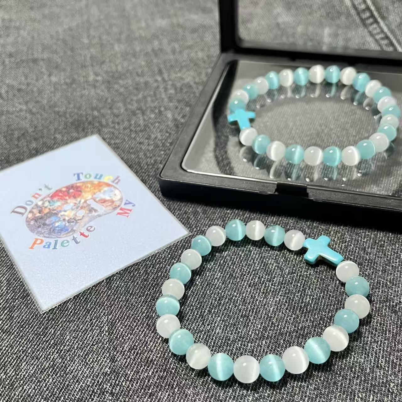 Premium packaging of SpiritPalette bracelet including a matte black floating frame box and a signature Don't Touch My Palette collector card.